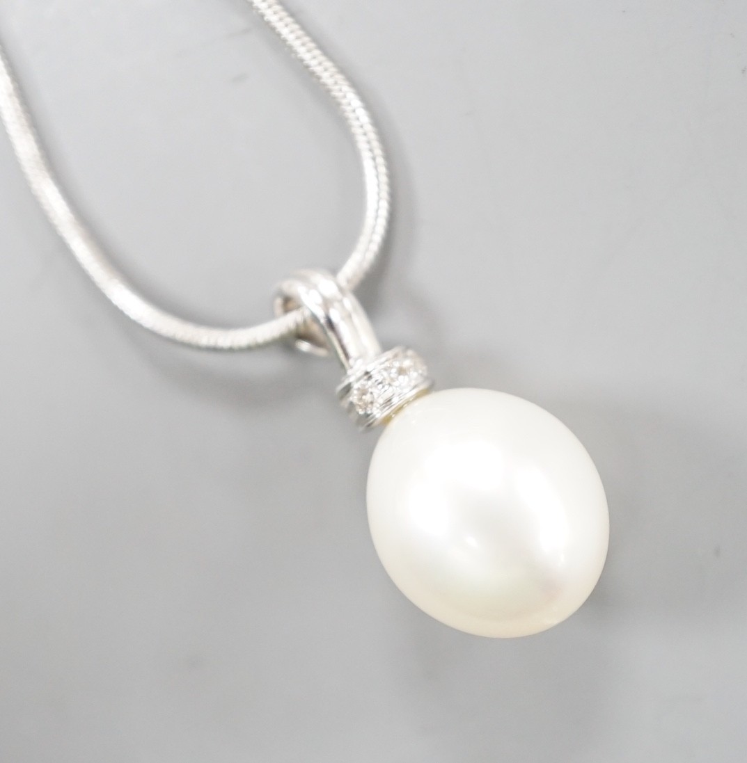 A modern 18ct white, gold, cultured pearl and diamond set pendant, 20mm, gross 2.7 grams, on a modern 9ct white gold chain, 44cm, 4.2 grams.